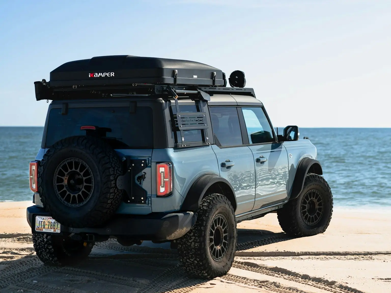 a jeep parked on a beach near the ocean